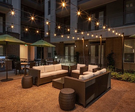 outdoor seating area with string lights and patio furniture at The Ash at  Branch