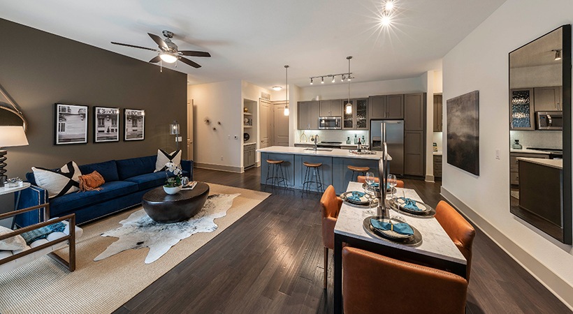 a living room and kitchen area with a blue couch at The Ash at  Branch