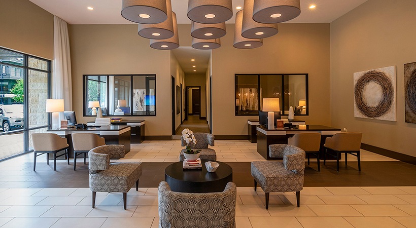 the lobby of a hotel with large windows and chairs at The Ash at  Branch