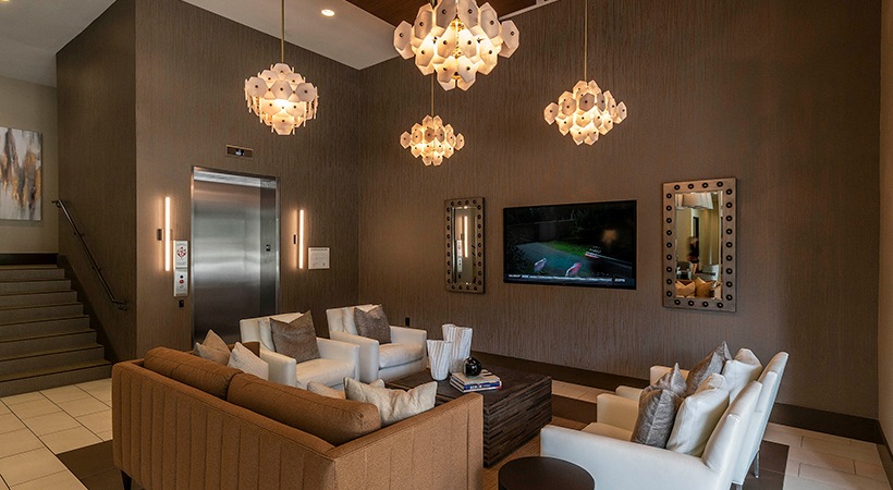 a living room with couches, a television and a chandelier at The Ash at Branch