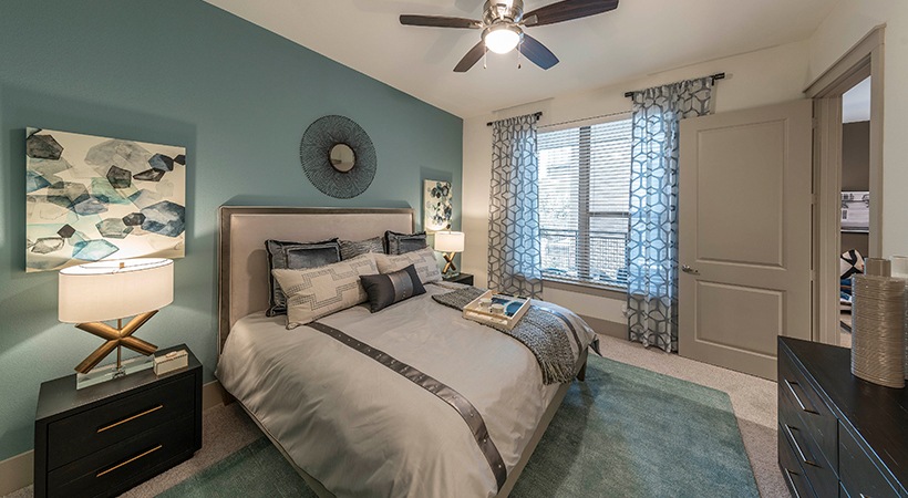 a bedroom with blue walls and ceiling fan at The Ash at  Branch